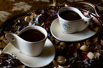 Cups of coffee with petals 