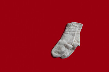 Traditional bulgarian woven socks handmade by an old grandma, isolated on red background