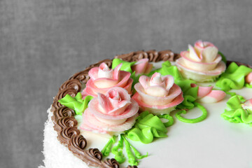 Cake with cream flowers close-up. Celebratory cake on a gray background. Cake decoration