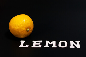 Fresh yellow lemon at the left of the screen. The inscription at the bottom. 