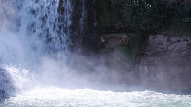 Mist rises up vertical wall at base of powerful Lundbreck Waterfall
