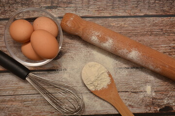 utensili da cucina e ingredienti per preparazione di una torta o pasta fresca su tavolo di legno...