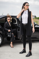 Female Bodyguard. Celebbrity bodyguard and VIP protection services. Black suit and walkie talkie....