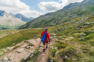 Fototapeta premium Young backpacker hiking a trail in the Alps mountains in Austria