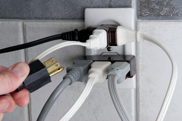 Overloaded Electrical outlet with no room for more plugs - obrazy, fototapety, plakaty