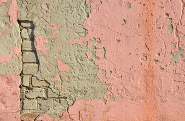 old brick wall with fragments of plaster and pink paint
