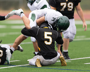Football players displaying amazing athletic ability while making plays during a game