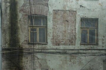 Old brick wall. Closed with a plastic net for safety reasons. Abandoned 19th century house in the...