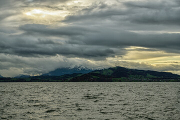 Zugersee lake and Mount Pilatus covered by clouds as seen from Zug in Switzerland