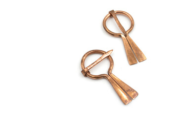 Isolated photos of a medieval copper fibula