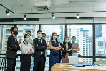 Diverse business people group with face mask protect from Corona virus standing together as team in office,Support and collaboration together to overcome pandemic of Corona virus to reopen business.
