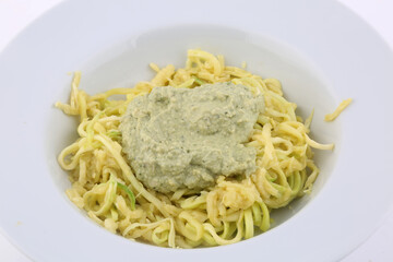 zucchini spaguetti with green pesto as delicious vegan healthy food