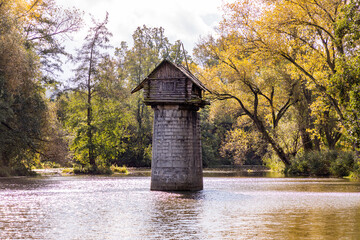 Wooden cottage on abandoned bridge pillar in autumn sunny day