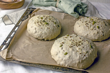 Yeast-free bread dough formed into baking loaves on a baking sheet. The process of making natural homemade sourdough bread with your own hands.Self-made bread at home