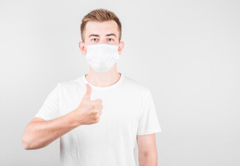 Portrait of a handsome American man wearing medical protective mask standing with a raised finger shows ok,approved sign, Isolated on white background.