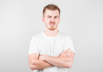 Obraz premium Portrait of young disgusted man in white shirt