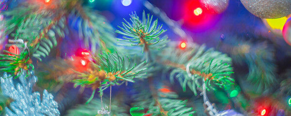 Fototapeta na wymiar Bright christmas tree with decorations and colorful lights, soft focus blurry background