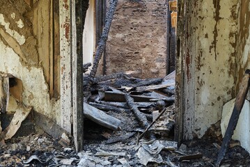 part of a burnt destroyed room with an empty door frame after a fire