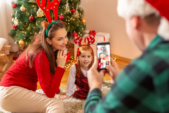 Man taking photos of his wife and daughter for Christmas