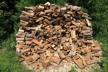 Heap or island of firewood. Alternative and cheap energy source for heating. Heating season. Wooden logs. Wooden fuel. Stock of renewable resources for the winter when energy prices rise