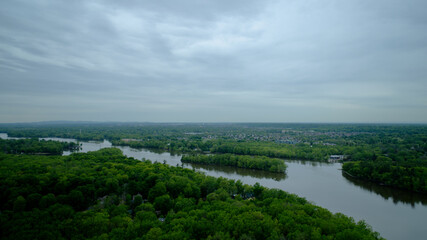 Obraz premium Aerial view of the Mille Iles river on a cloudy summer day with grey clouds 