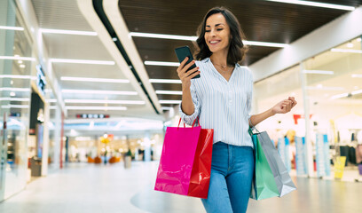 Modern gorgeous young smiling woman in trendy stylish clothes with bright colorful shopping bags is...