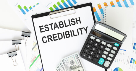 establish credibility. text on notepad pages on white paper on light background near calculator and...