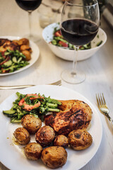 fried chicken with potatoes, salad and wine, dinner
