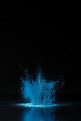 Blue holi powder explosion on black, traditional Indian festival of colours