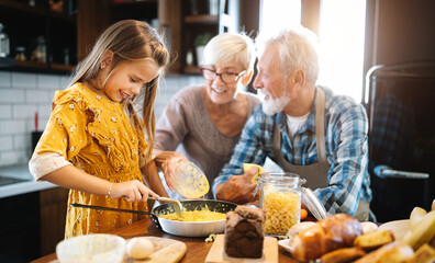 Happy grandchildrens girls having breakfast with her grandparents