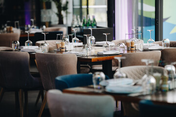 tableware Glasses, flower fork, knife served for dinner in restaurant with cozy interior
