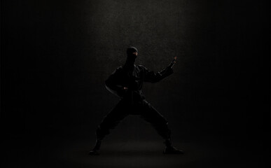Fototapeta na wymiar japanese ninja in black uniform on black background