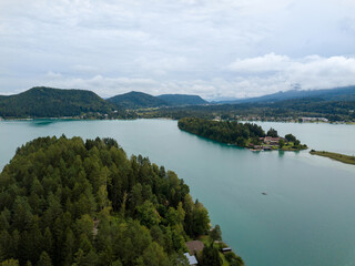 Fototapeta na wymiar Aerial view on Lake 'Faaker See' in Carinthia (Kaernten), Austria with its famous turquoise water on a cloudy summer day