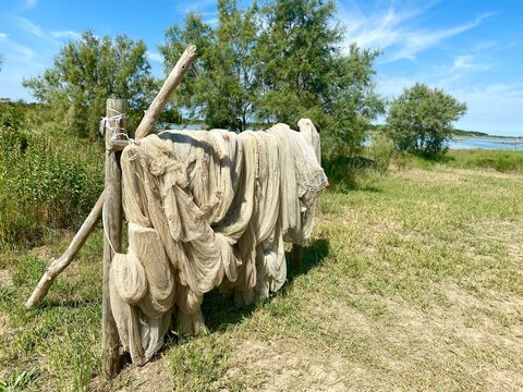 old fishernets are drying on a wooden rack in the sun