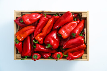 Crate with red peppers on white background