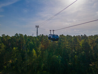 Fototapeta na wymiar Cable car in Druskininkai from city center to snow arena over river of Nemunas
