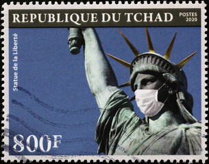 The Statue of Liberty with antivirus mask on postage stamp