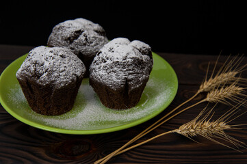 chocolate muffins on a green plate on a dark background