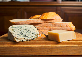 Queso y rebanadas de pan sobre una tabla de madera