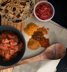 Curry and roti with curry spice and wooden spoon