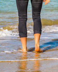 Young Woman Legs at Shore of Beach