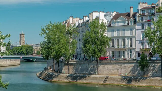 Saint-Louis bridge timelapse with houses on Orleans waterfront. Two islands on the River Seine in Paris, France, called Ile de la cite and Ile saint Louis. Paris, France.