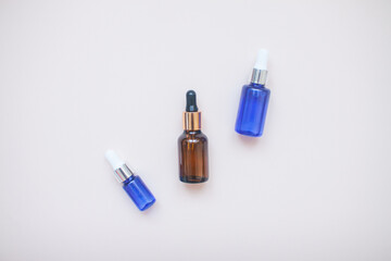 Bottles with face serum on a light background. Beauty industry.