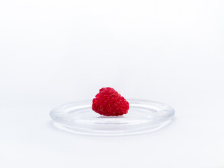 Red ripe raspberries in a glass mini plate. Gourmet dessert