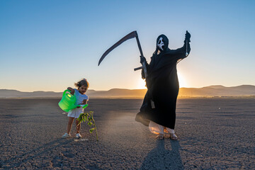 global climate change concept. horror grim reaper holding is holding a clock in one hand and a...