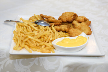 Fast food dish with fried potatoes and meat. Unhealthy high-calorie food of public catering.