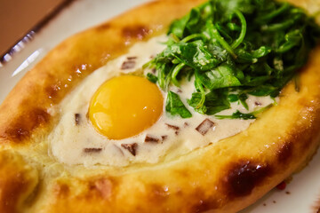 Khachapuri in Adjarian. Open pie with mozzarella and egg. Georgian cuisine.