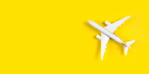 model of passenger plane on yellow background. Flat lay travel concept design. Copy space
