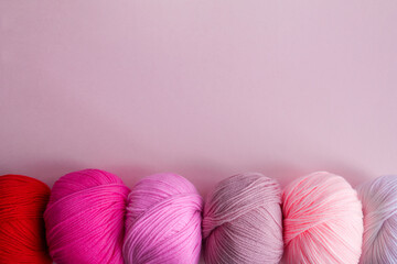 Acrylic balls of yarn on a pink background. A nuanced combination of colors.