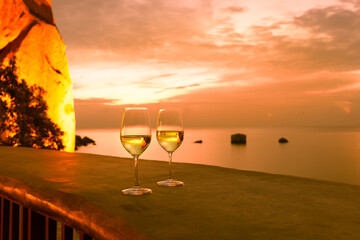Wine and a beautiful sunset ocean view. Romantic vacation setting. 